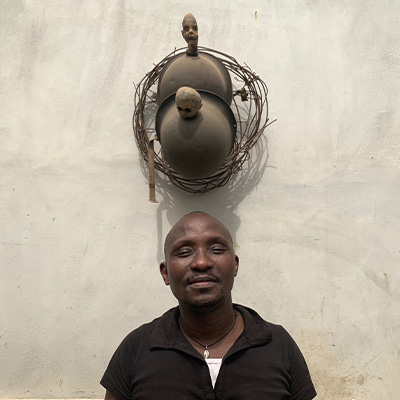 l'artiste gerard quenum et une de ses sculptures
